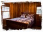 2nd bedroom w/ queen bed and fine wood furnishings and paneling.