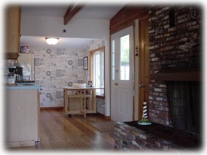 Kitchen leads to back deck. Fireplace on right.