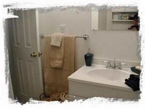 Bathroom has ceramic tile shower, separate vanity and storage area