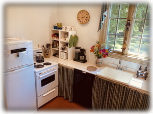 The kitchen has a fridge/freezer, 4-burner stove, microwave, & dishwasher.
