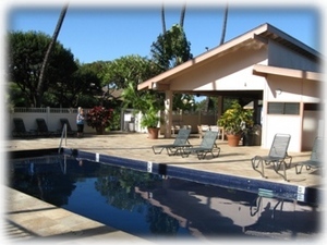 Pool area has adjacent covered BBQ's and tables