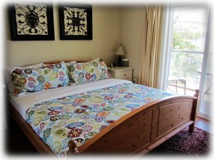 King bed in upstairs bedroom. Room has TV and private view balcony.