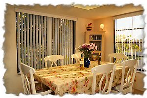 Dining area off kitchen is surrounded by large windows