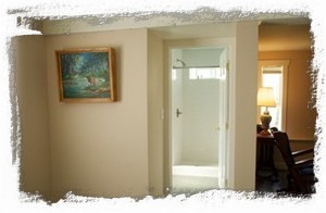 View from bedroom into tiled shower and bathroom and living area