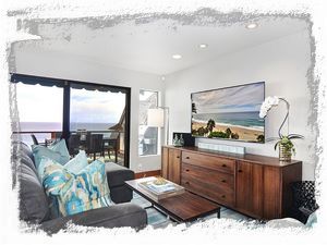 Living room has ample comfy seating, a 60' Samsung TV, and sit down ocean views