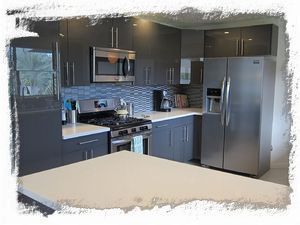 Completely remodeled kitchen with slick gray cabinetry and stainless appliances